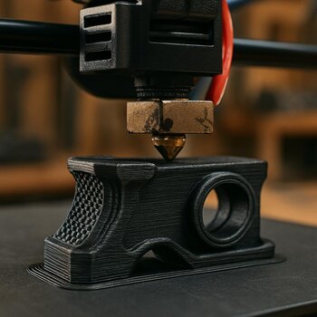 Close-up of a 3D printer nozzle making a small mounting bracket